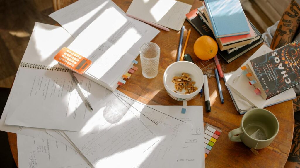An organized study table for students, featuring a laptop, papers, and a cup of coffee to enhance productivity